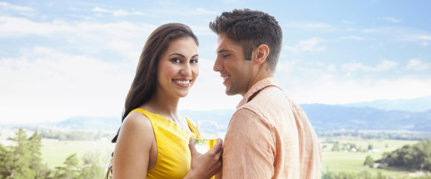 Close-up of a couple relaxing with a glass of wine with mountains in the background