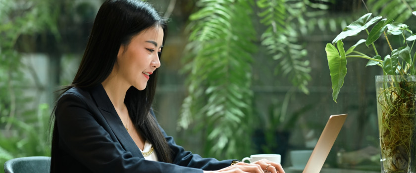 Smiling businesswoman using laptop.