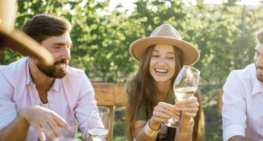 Friends Wine Tasting during a weekend getaway from New York City holding a wine glass and laughing